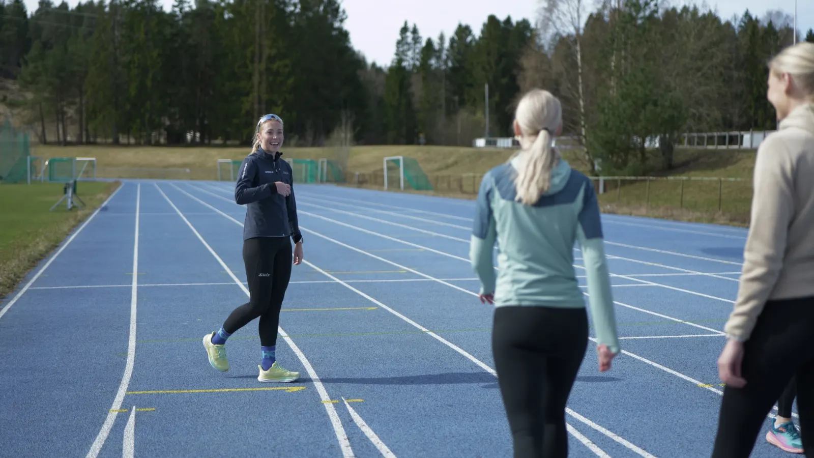 Løpecoach Veronica Undseth på løpebanen sammen med to løpere